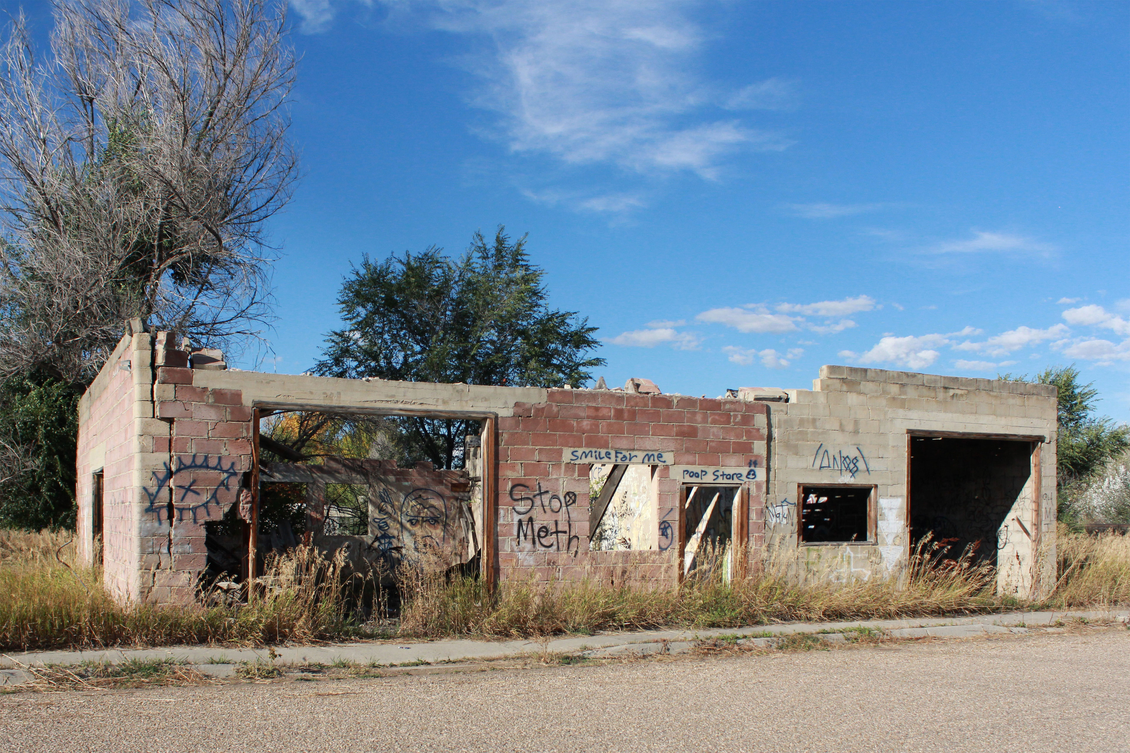 The remains of a stone building where someone had spray-painted “Stop Meth” and other graffiti on its roofless walls.