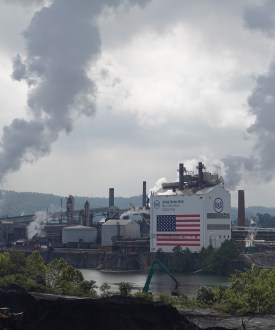 A view of the Clairton Plant and Clairton Coke Works facilities along the Monongahela River. Smog billows out of smokestacks from both facilities.
