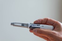 A hand holds a Wegovy injector.